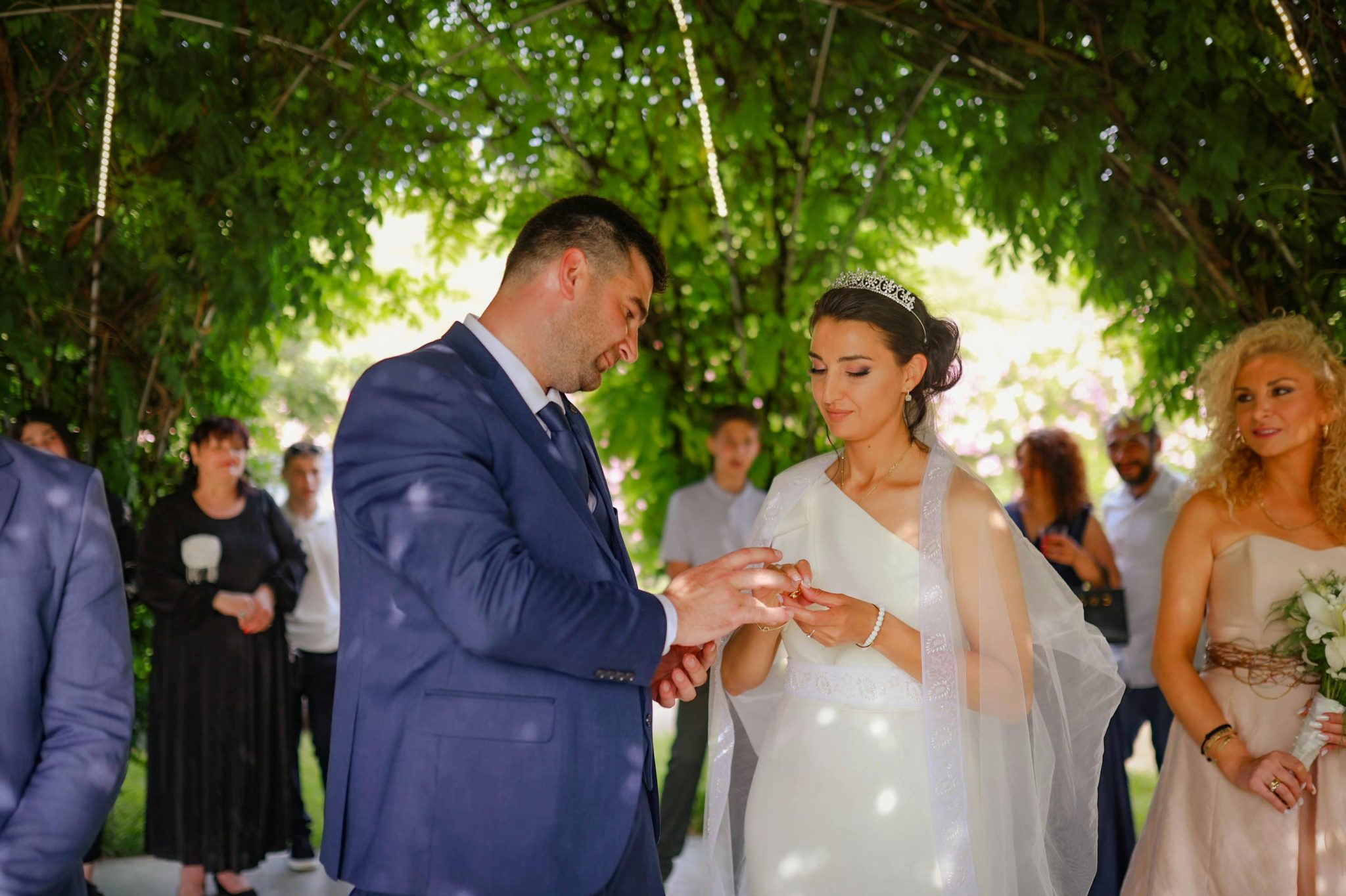 Aman and Priya exchanging rings during their civil wedding ceremony, captured by professional wedding photographer Suraj Verma under a leafy green outdoor setting.